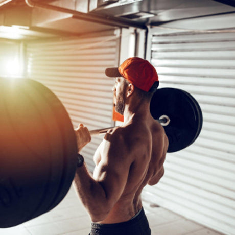 bare chestet male with barbell in a garage gym